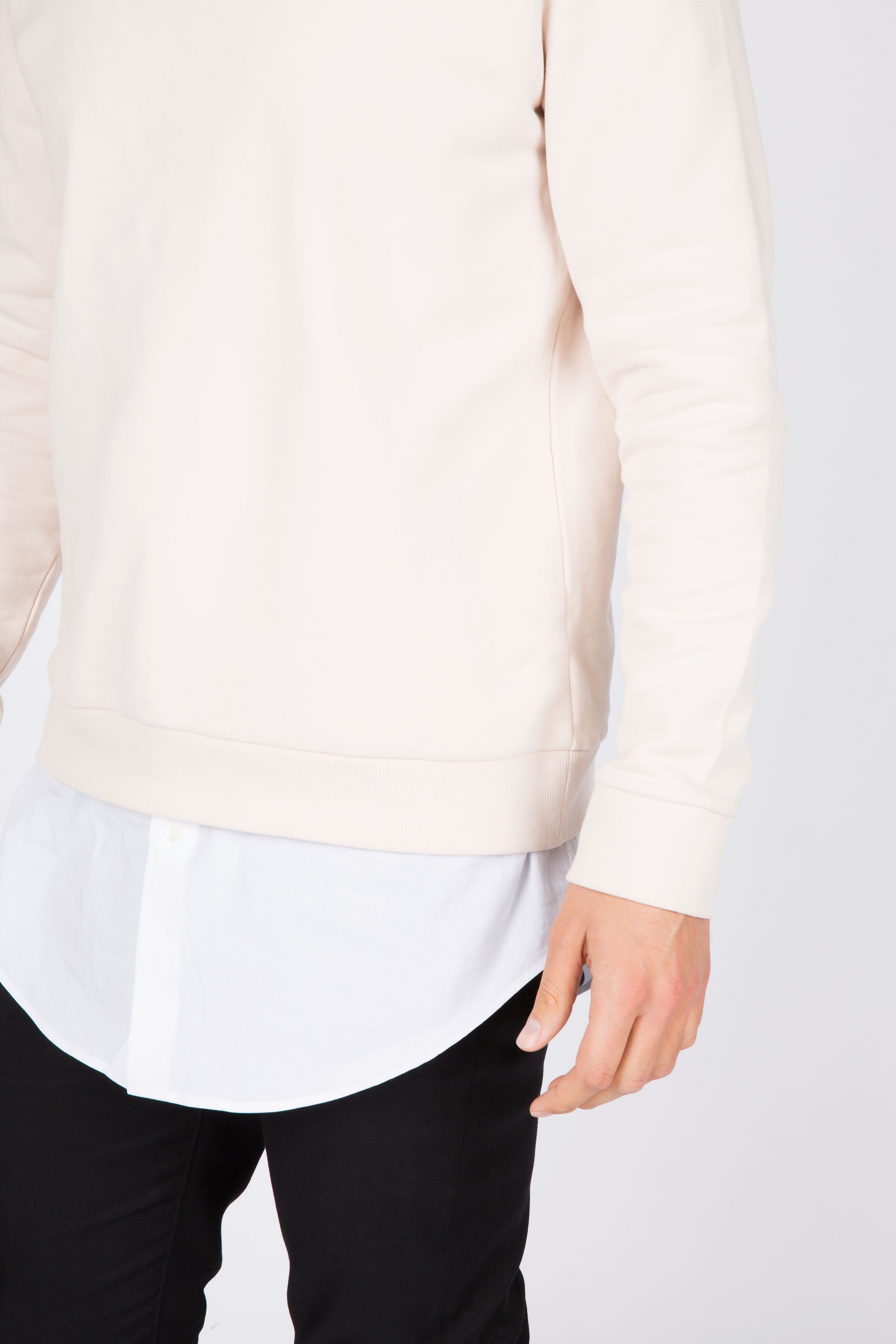 a guy wearing a white shirt and a cream sweater